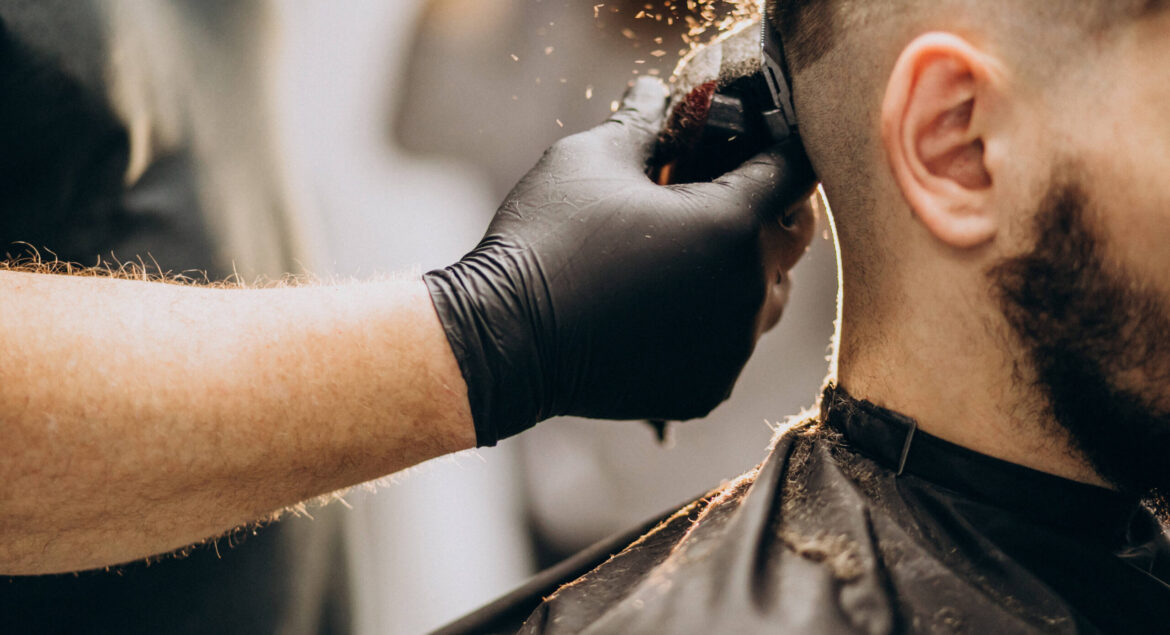 Client doing hair cut at a barber shop salon